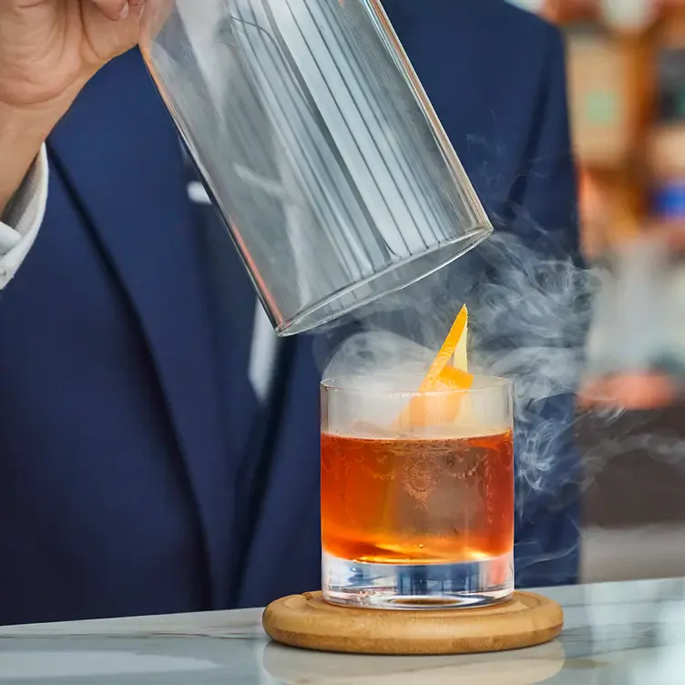 A barman prepares an Old-Fashioned cocktail at Orelle Birmingham, one of the best romantic restaurants in Birmingham.