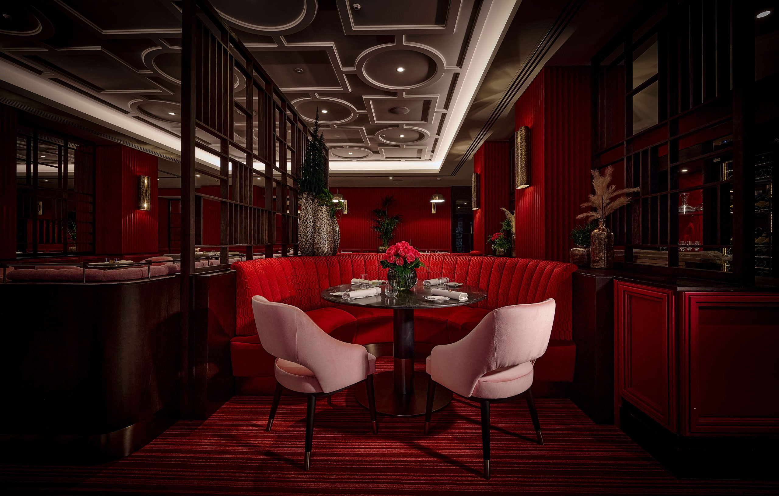 Red velvet booths and dark wood decor at the Pem restaurant, London