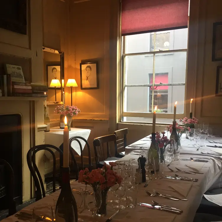 A table with a white tablecloth and candles at Andrew Edmunds in Soho, one of the best romantic restaurants in London