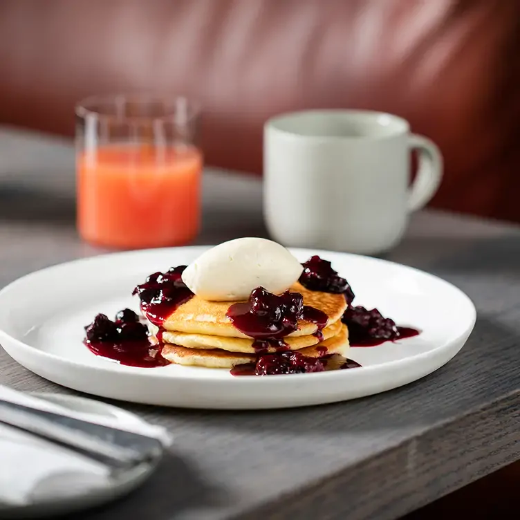 A pancake stack topped with fruits and a scoop of ice cream at Kitchen E20, one of the best restaurants for brunch in London