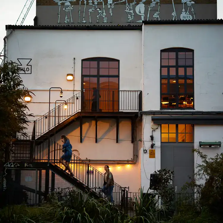 The white façade with tall windows and external staircase at Silo London, the world's first zero waste restaurant