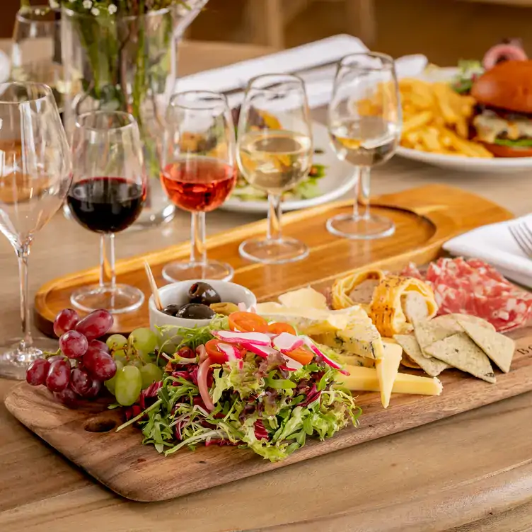 A wine tasting featuring red, rosé and white wine and a ham and cheese board at Bolney Wine Estate Ltd, one of the most sustainable wineries in the UK