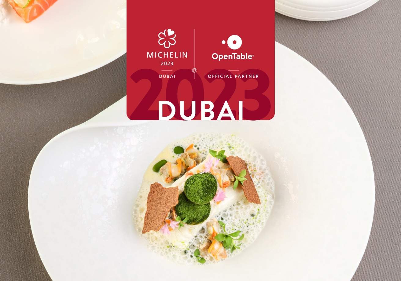 A composed seafood dish on a white plate with a Michelin logo on top to indicate this is a blog post announcing the michelin star winners in Dubai