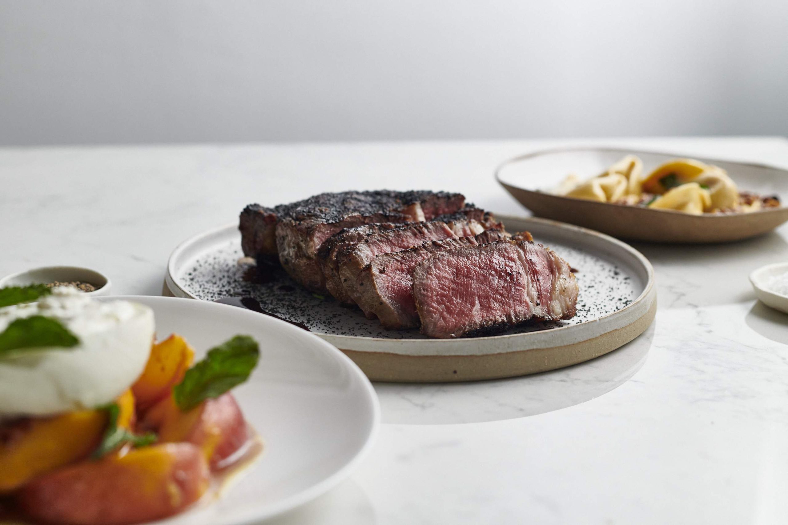 A white table with a plate of sliced meat at Host, a restaurant in London.