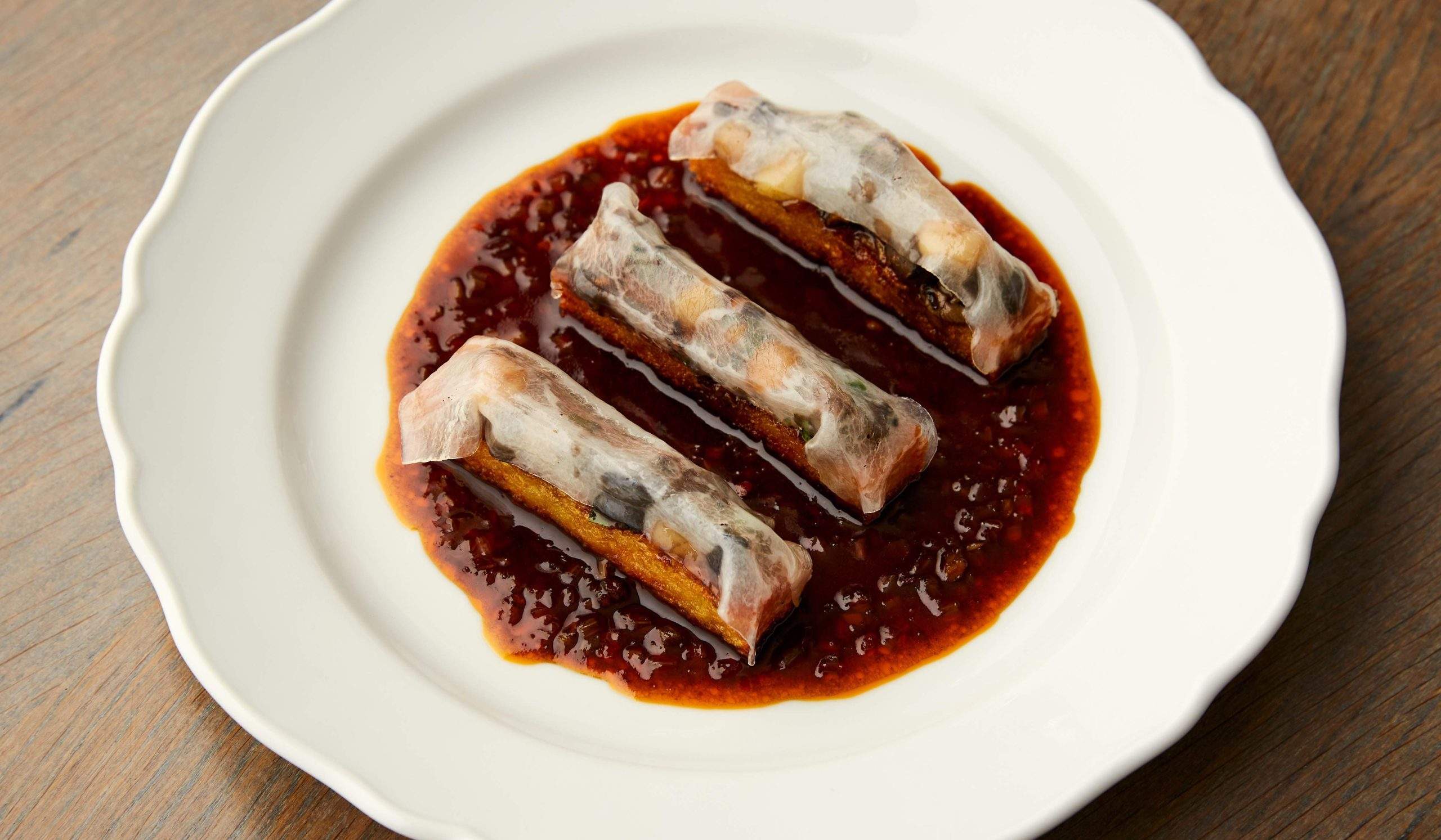 Three canapes sit on a plate surrounded by gravy at The Midland Grand Dining Room, a restaurant in London