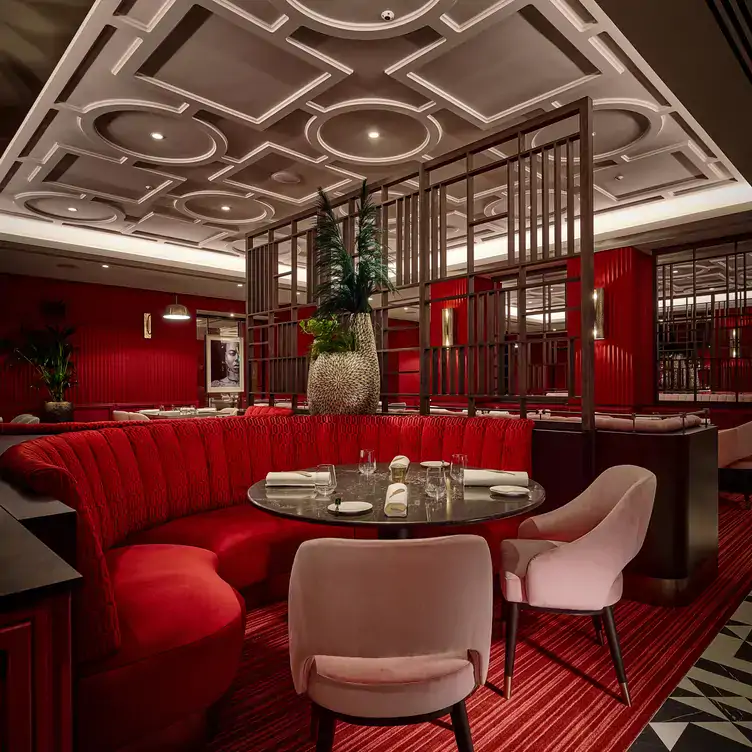 A red velvet booth seating area at The Pem, one of the best restaurants for Christmas in London.