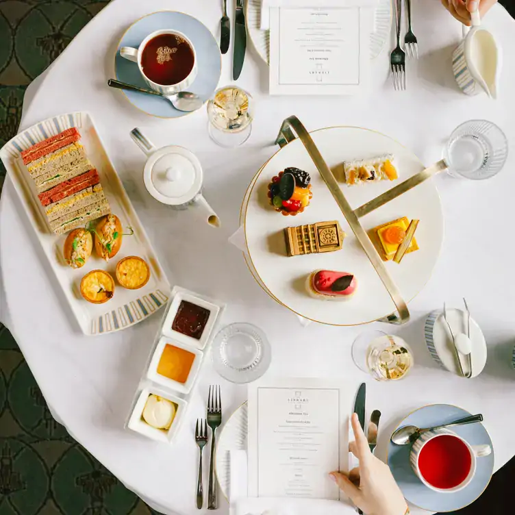 A table set with cups of tea, finger sandwiches and pastries at The Library at County Hall, one of the best festive restaurants in London.