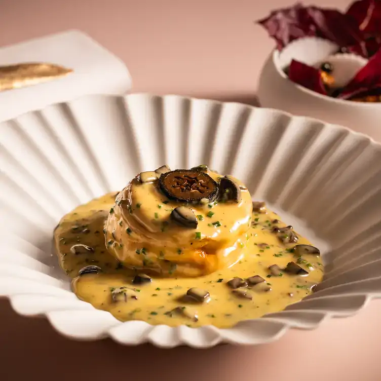 A dish smothered in a creamy sauce from the menu at The Pem, one of the best London Christmas restaurants.