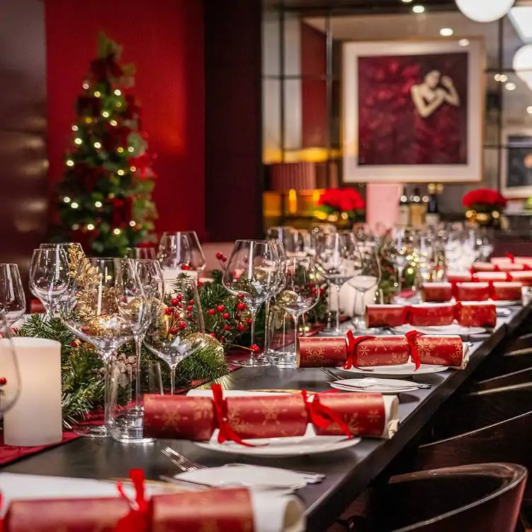 A long table at The Pem, one of the best festive restaurants in London, set up for a Christmas party with wreaths and holly decorations.