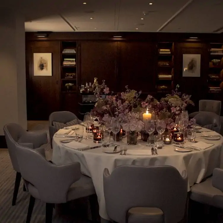 A private dining room at Indigo at One Aldwych, one of the best festive restaurants in London, with floral decorations in the centre of the table.