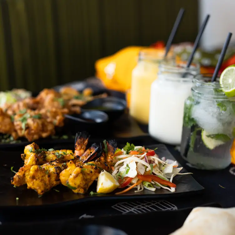 A main dish of a Prawn Sizzler accompanied by fresh juices and cocktails at Aamchi Mumbai, one of the best Indian restaurants in Manchester. Credit: Aamchi Mumbai