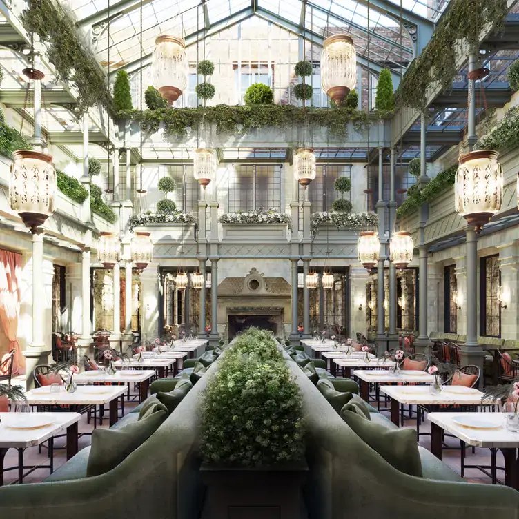 The main dining area of The NoMad London, one of the best restaurants for Christmas in London, showing a long series of tables and two mezzanine floors.