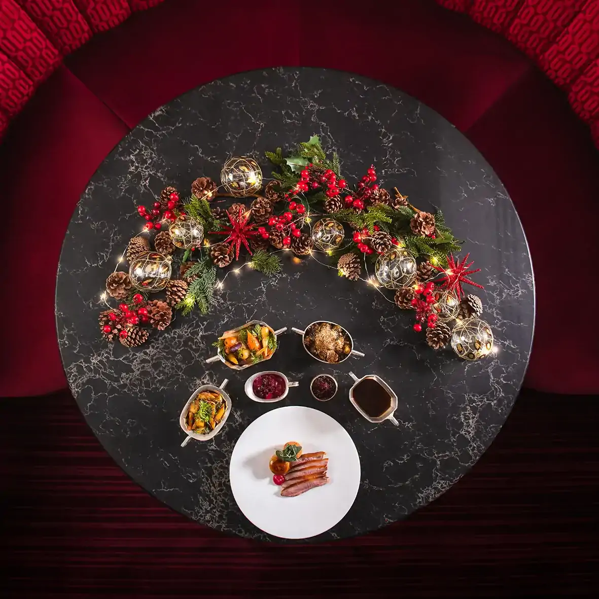 A table at The Pem, one of the best festive restaurants in London, decorated with Christmas wreaths and set with a selection of appetizers.