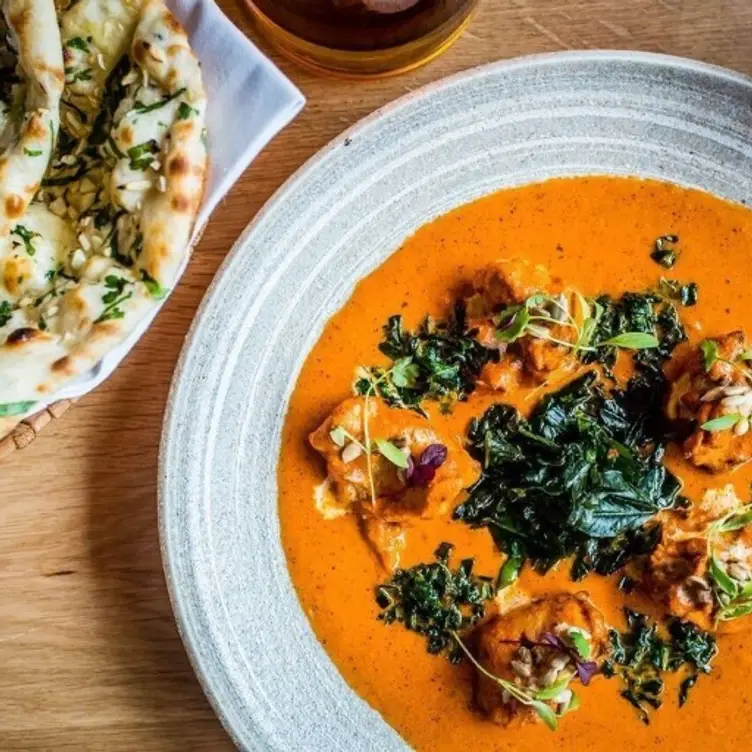 A dish of traditional curry with a side of garlic naan bread at Khandoker – Didsbury, one of the best Indian restaurants in Manchester. Credit: Khandoker - Didsbury