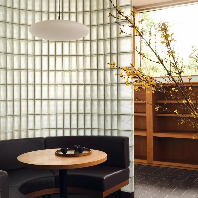 A table and booth seating area in a modern minimalist setting at Maido Sushi, one of the best sushi restaurants in London.