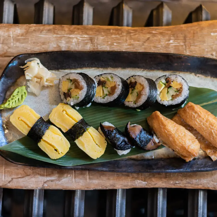 A mixed plate of sushi rolls and spring rolls well presented on a leaf at Michiko Sushino.