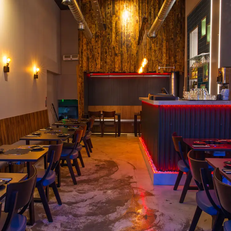 The interior of the restaurant with people, tables, chairs and a bar at Gogi Restaurant, one of the best Korean restaurants in London.