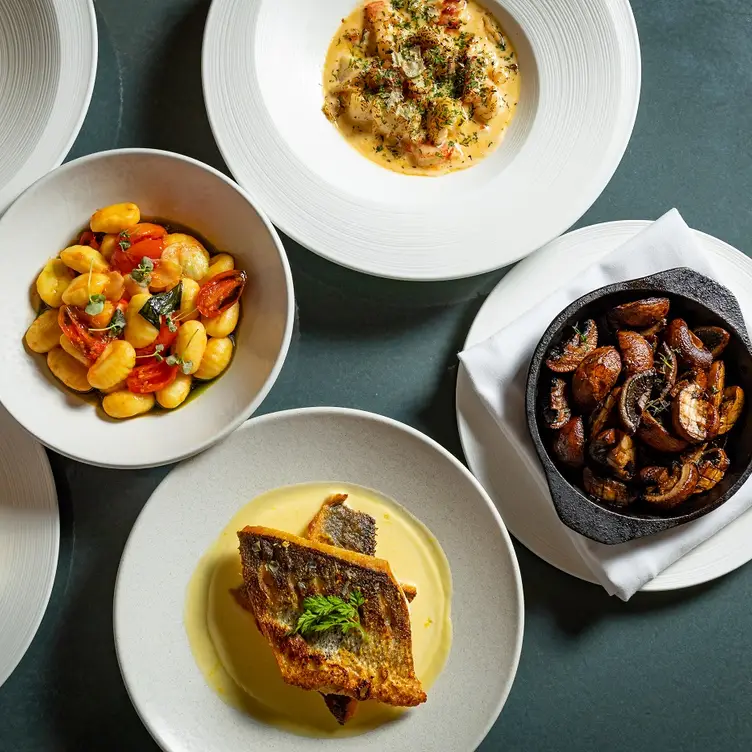 A spread of Mediterranean-inspired dishes, including gnocchi, fish and potatoes at Whitcomb's at The Londoner