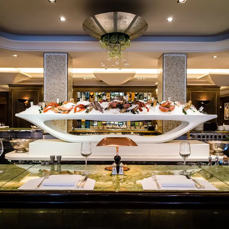 A large seafood display with ice sits in front of a table at Scott’s, one of the best seafood restaurants in London.