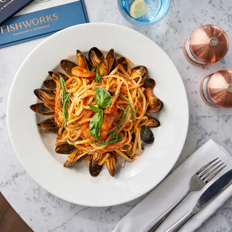 A seafood linguine dish on a marble-top table with salt and pepper shakers and cutlery at Fishworks - Covent Garden, one of the best seafood restaurants in London.