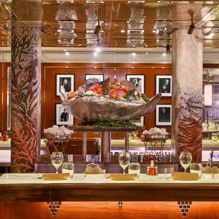 A large decorative clam shell sits between two columns beside a table at J Sheekey - The Restaurant.