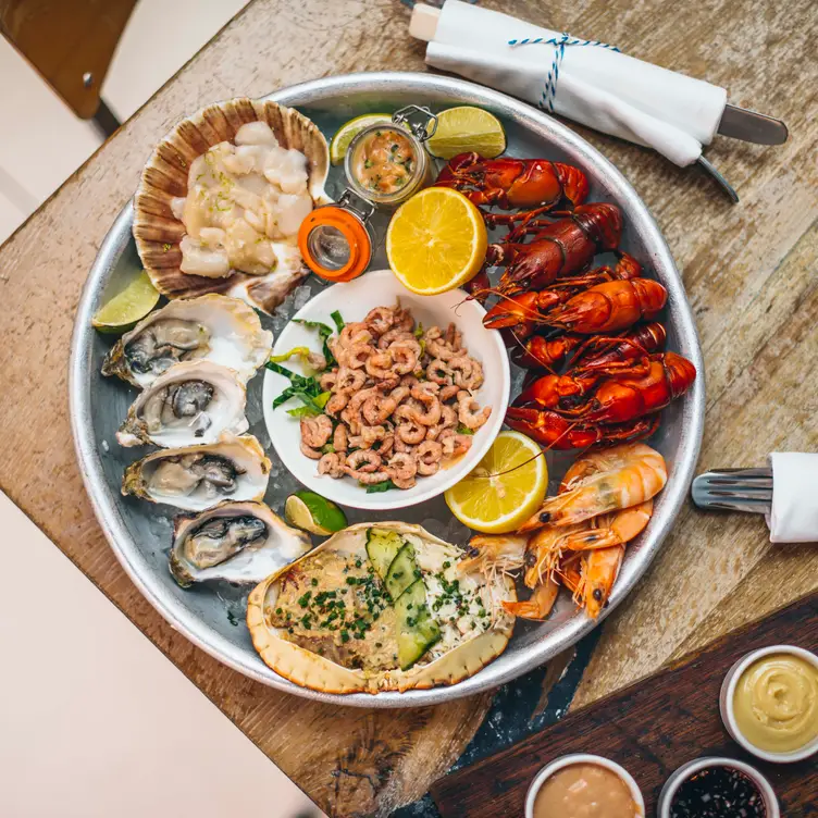 A shellfish platter with oysters, lemons and side sauces at Fish Market, one of the best seafood restaurants in London.