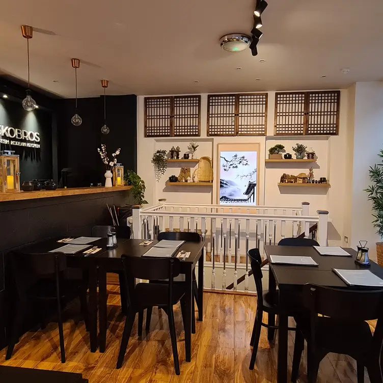 The interior of the restaurant, with tables, chairs and a bar at 3KOBROS Korean Restaurant, one of the best Korean restaurants in London