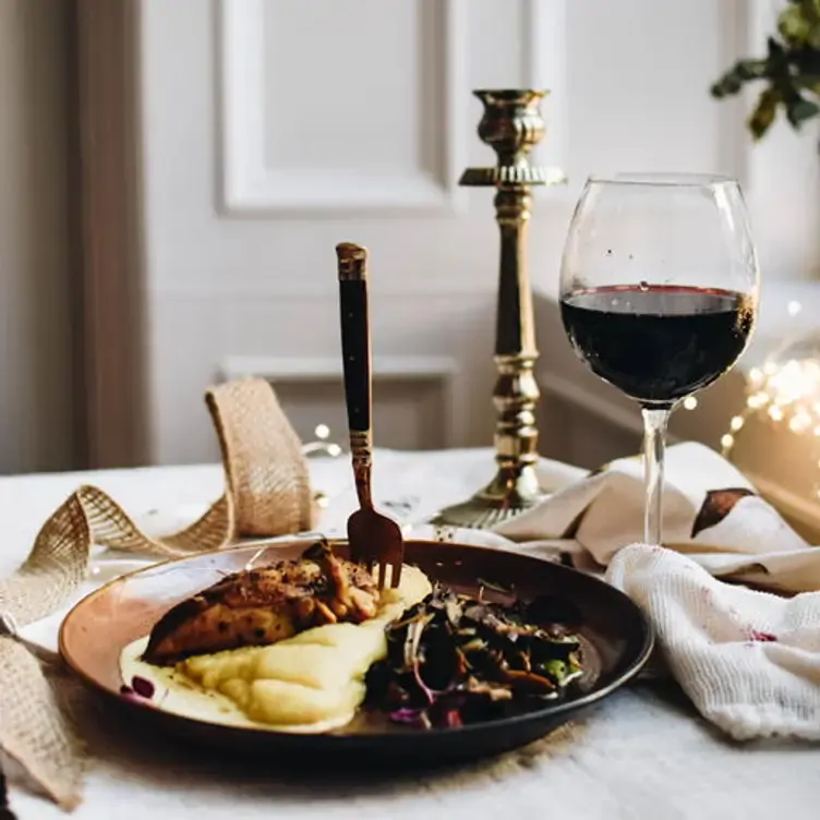 A plate of meat and mashed potatoes and a glass of red wine at Le Bistrot.