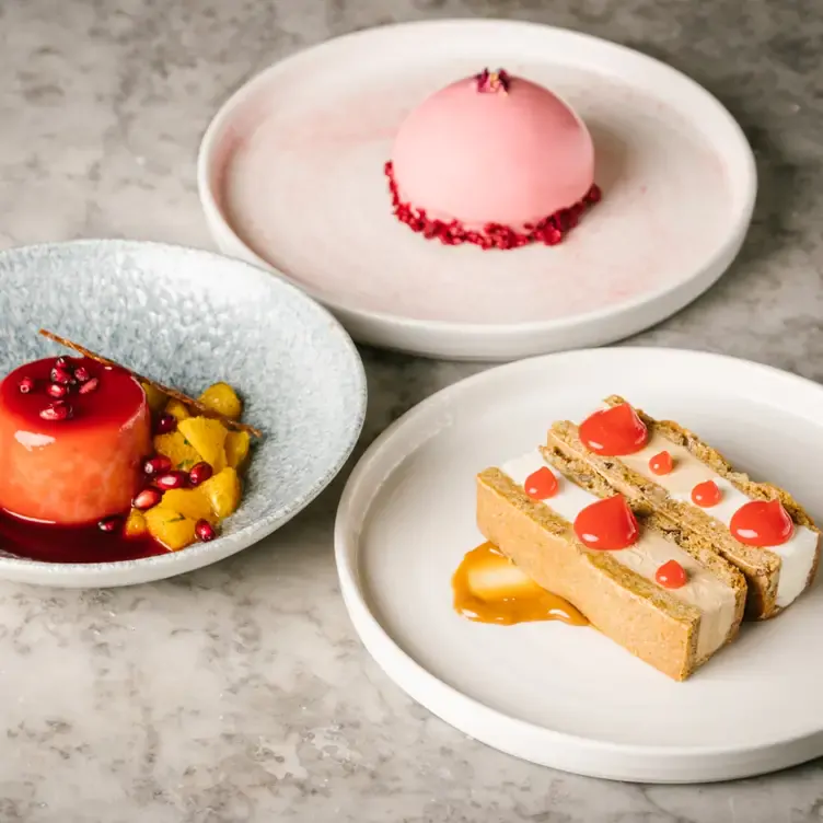 Three plates of colourful desserts at Champagne Central, in Glasgow.