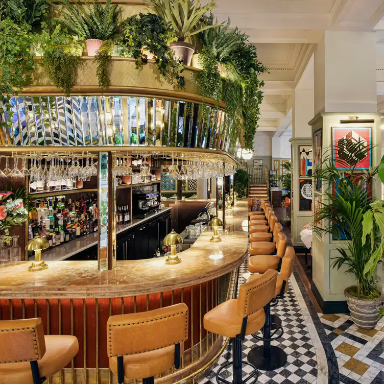 The curved bar and row of bar chairs at the Ivy Buchanan Street Glasgow, one of the best date night restaurants in Glasgow.