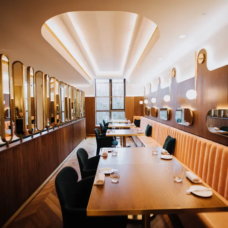 Tables line a wall in the glowing, warm interior of Glovers Alley.