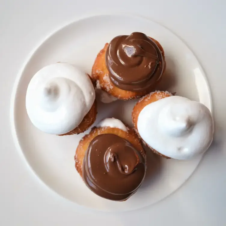 A plate of chocolate and merengue covered doughnuts at Menagerie Restaurant, one of the best bottomless brunch restaurants in Manchester.