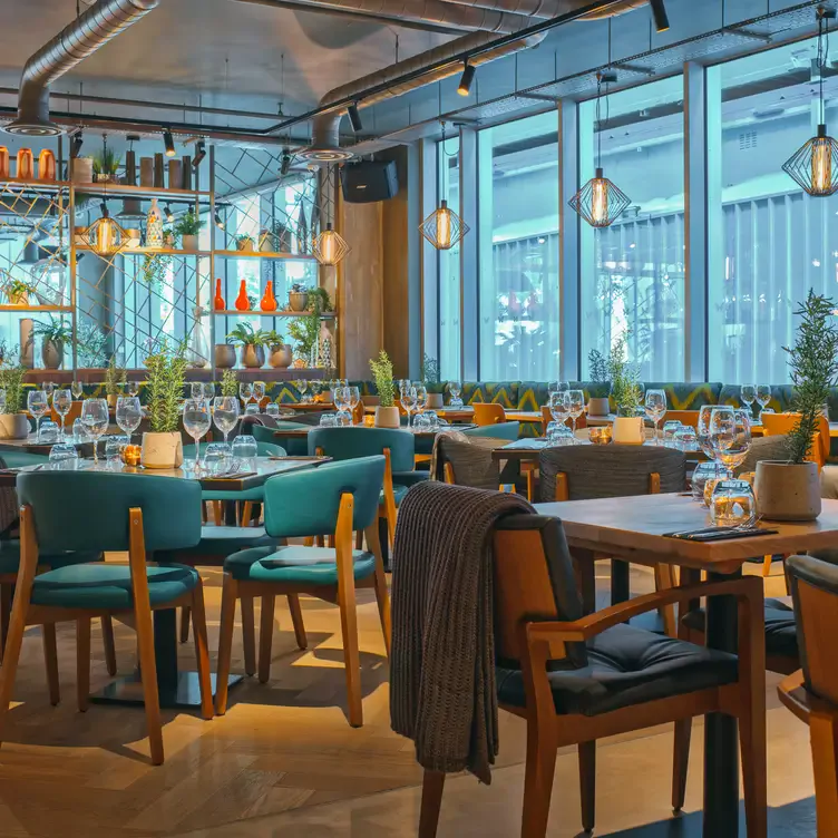 The blue-themed dining room with wooden tables and chairs at The Anthologist One St Peter’s Square.