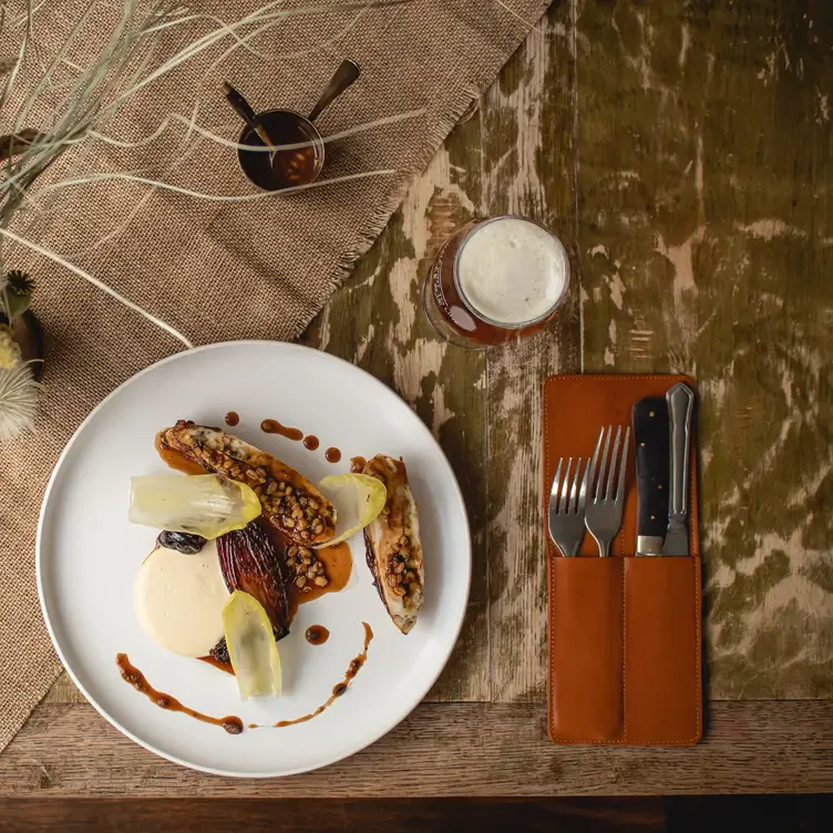 A carefully plated dish served alongside a glass of beer at Harwood Arms, one of the best restaurants in London with a MICHELIN star.