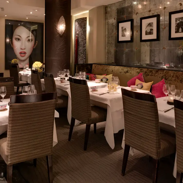 The dining space at Kai, with paintings lining the walls and colourful cushions on the booth seating.