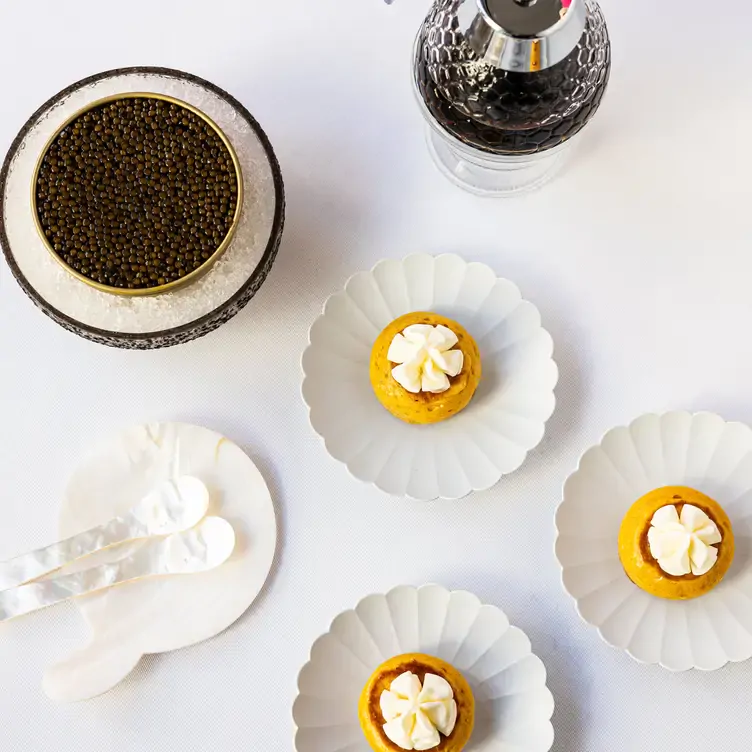 Multiple dishes of baked fruit topped with cream served at Restaurant Gordon Ramsay, one of the best MICHELIN restaurants in London.