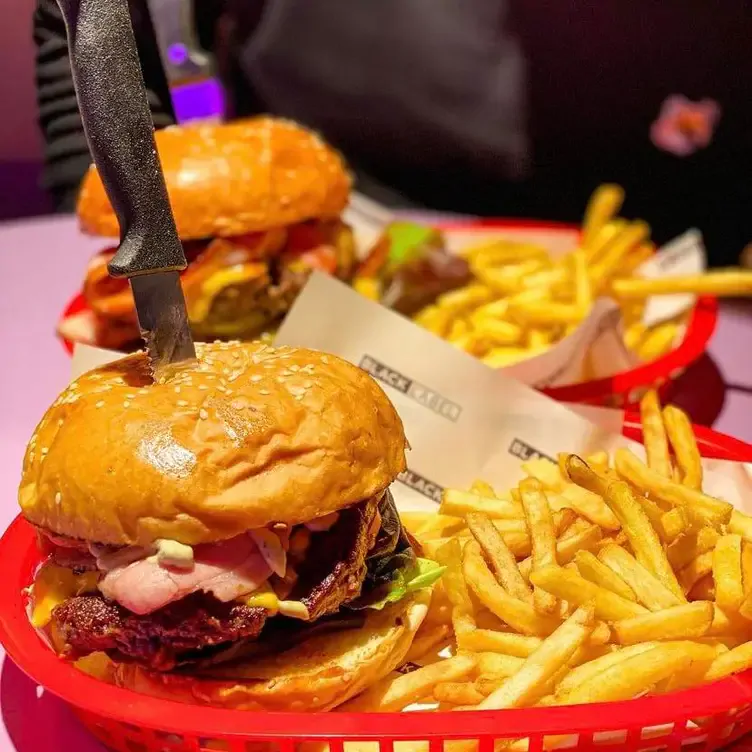 A table with trays of burger and fries at Karen’s Diner, one of the best bottomless brunches in Manchester.