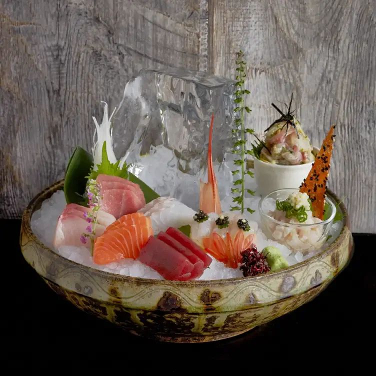 A cold bar bowl filled with ice, and various raw fish for sushi and sashimi dishes at ROKA, one of the best fancy restaurants in London.