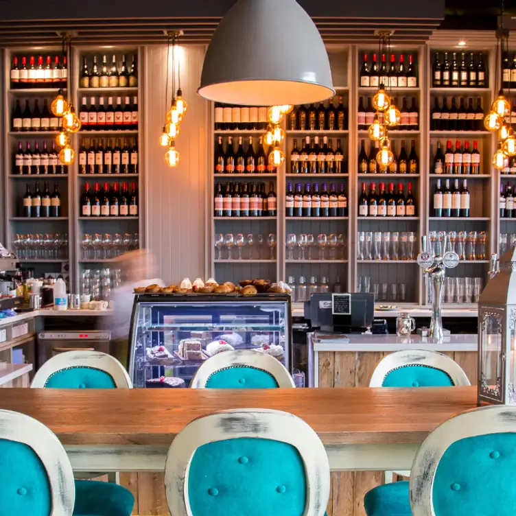 An island table with blue stools and wine shelves at Gourmet Food Parlour, which serves the best brunch in Dublin.