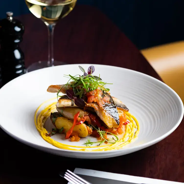 A plate of slices of fish stacked on top of each other and topped with a small amount of salad at Purty Kitchen, one of the best pubs in Dublin.