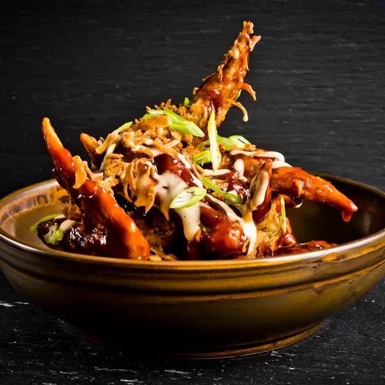 A bowl of Smokey BBQ chicken wings with BBQ sauce and garnish at The Forest Bar Restaurant, one of the restaurants with the best brunch in Birmingham.