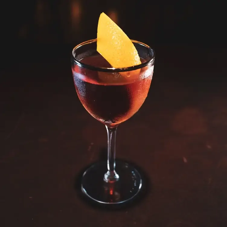 A red-tinged cocktail garnished with a lemon peel served at Dury Buildings, one of the best pubs in Dublin for cocktails.