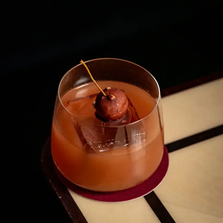 A cocktail sits with a chocolate-covered cheery on top at Isabel Mayfair, one of the best fancy restaurants in London.