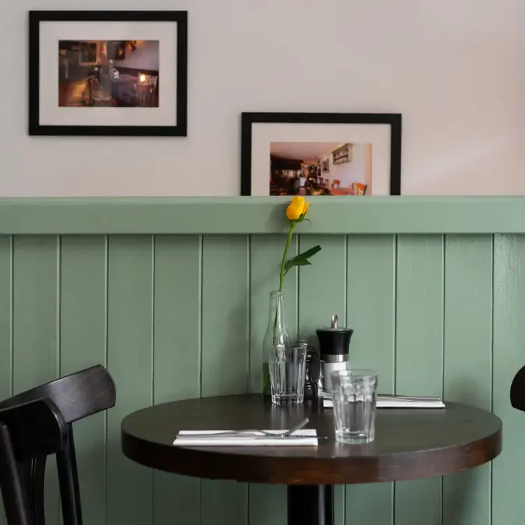 An empty table setting against a white and light green wall at Greenwoods, one of the best brunch restaurants in Edinburgh.