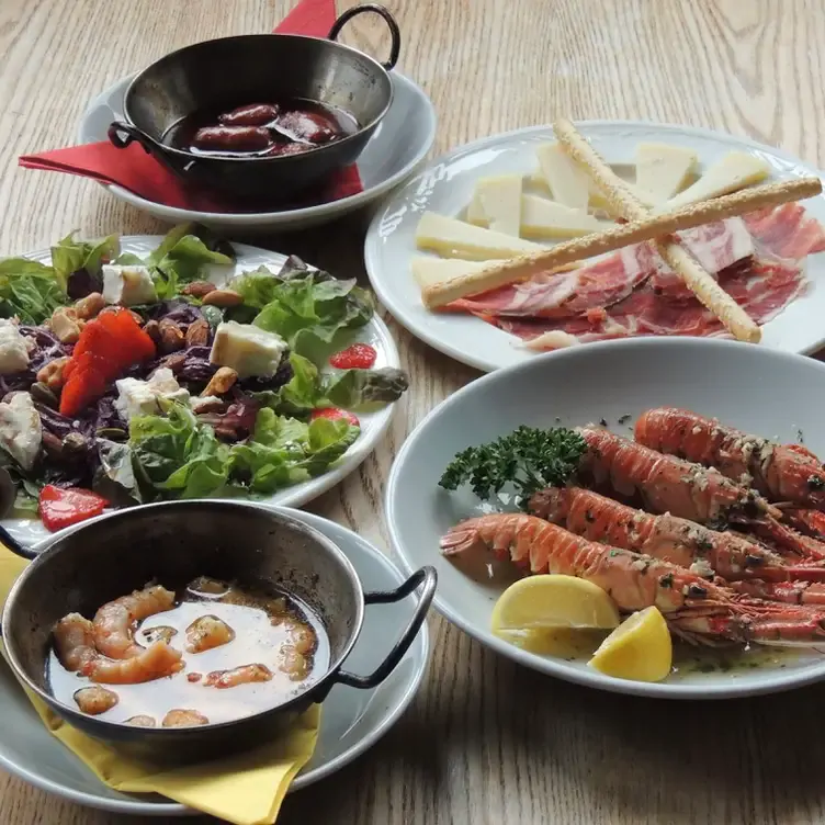 Various tapas dishes such as prawns, ham and salad on a table at Elena’s Tapas Bar and Restaurant.