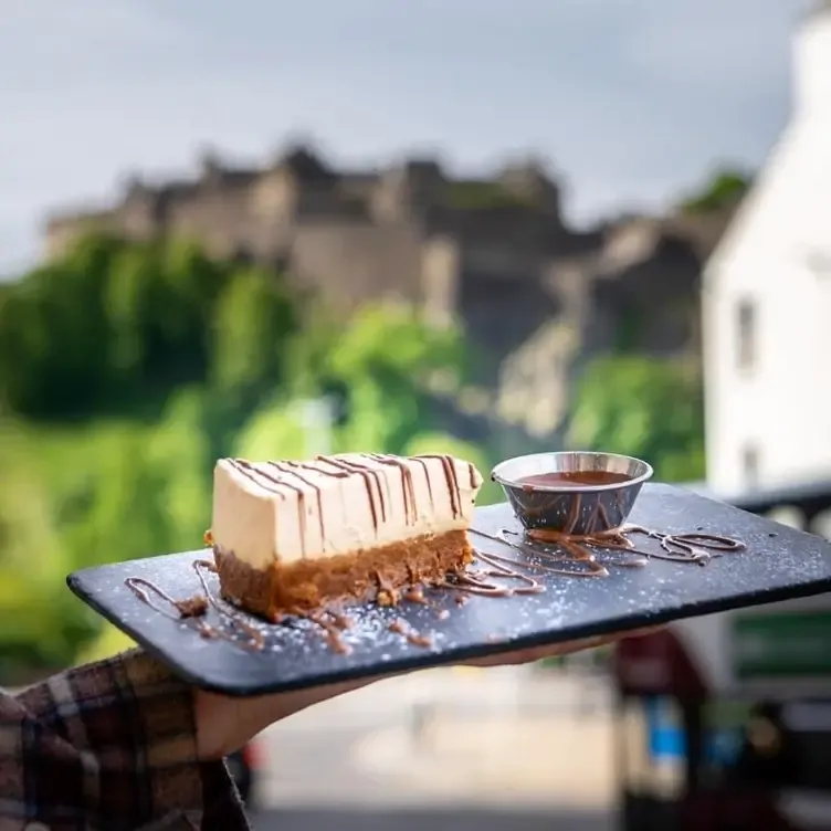 A slice of cheesecake with chocolate sauce at Coro Chocolate Café, one the restaurants with the best brunch in Edinburgh.