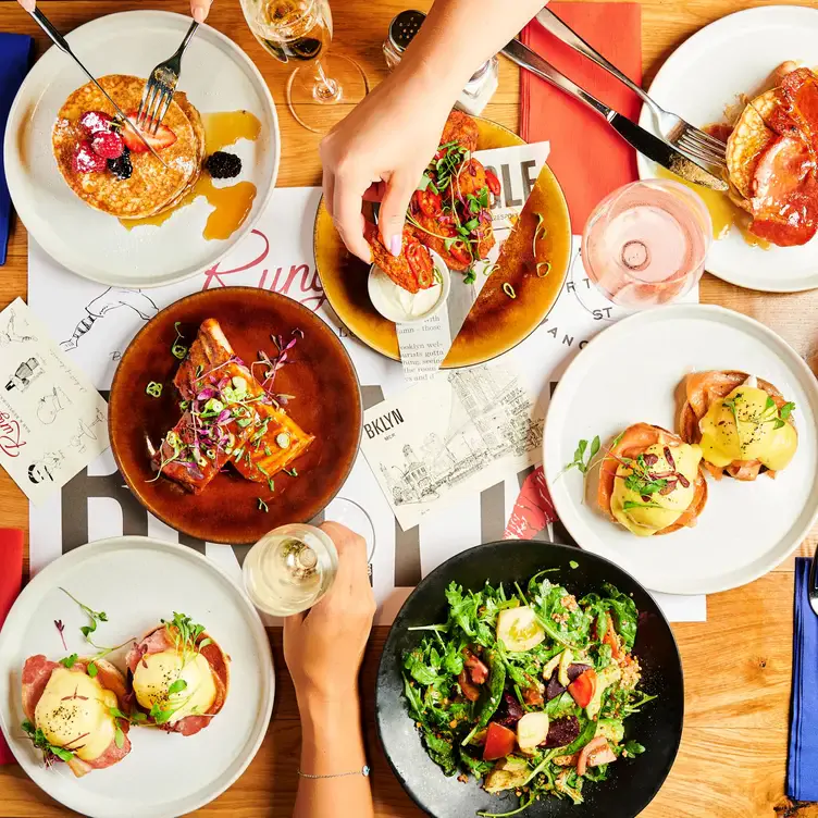 Diners sit at a table with various brunch dishes and glasses of prosecco at Runyon’s Restaurant at Hotel Brooklyn, in Manchester.