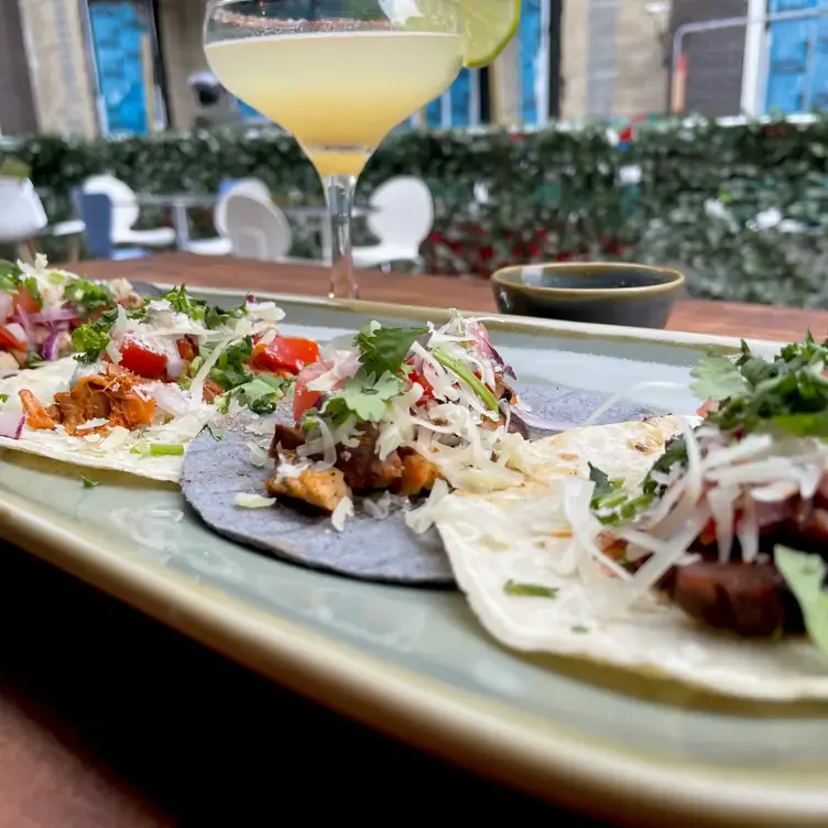 A cocktail and tacos on an outside table at Catalinas, one of the best Mexican restaurants in London.