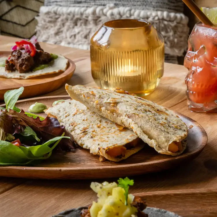 View of a table with Tacos and salad on plates at Amiga.