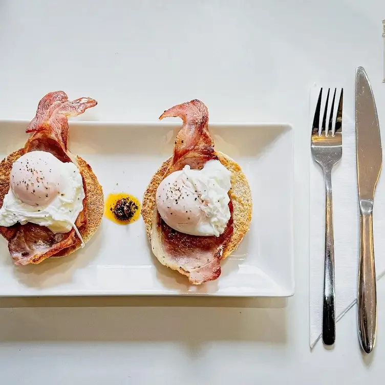 A dish of poached eggs and bacon on a muffin at Hanover 71 Café & Bistro, one of the best brunch restaurants in Edinburgh.